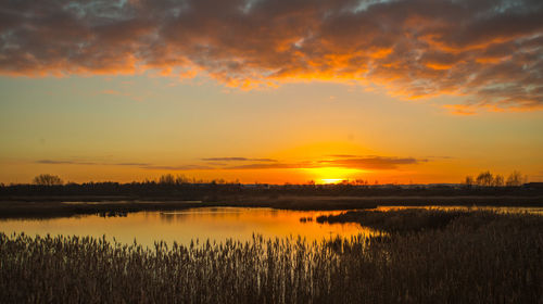 Scenic view of lake against romantic sky at sunset
