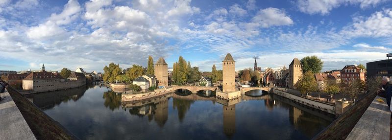 Panoramic view of bridge over river amidst buildings against sky