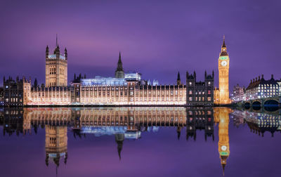 Illuminated big ben and houses of parliament against sky at night