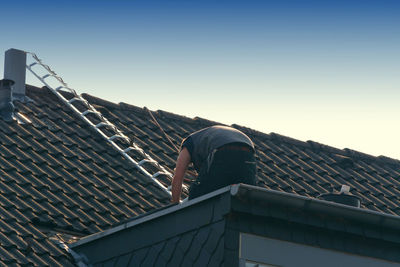 Low angle view of building roof against clear sky