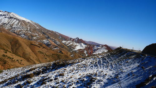 Scenic view of snowcapped mountains against clear blue sky