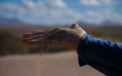 Close-up of person hand holding sand