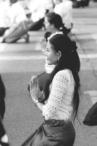 Side view of young woman sitting outdoors
