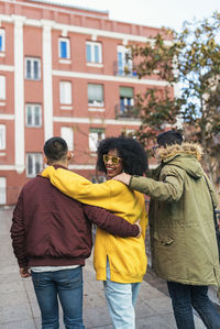 Woman with male friends walking on street