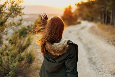 Rear view of woman standing against blurred background