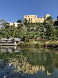 Scenic view of lake by buildings against clear sky