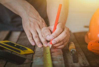 Midsection of woman holding pencils on table