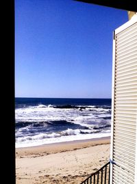 Scenic view of beach against clear blue sky