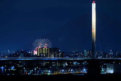 View of bridge and buildings against sky at night