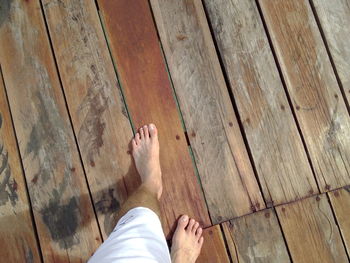 Low section of man walking on boardwalk