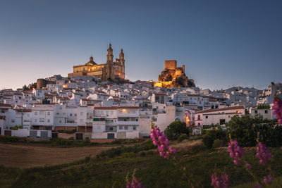 Buildings in city against clear sky