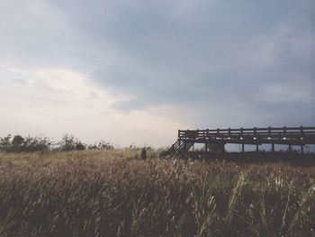 Scenic view of field against cloudy sky