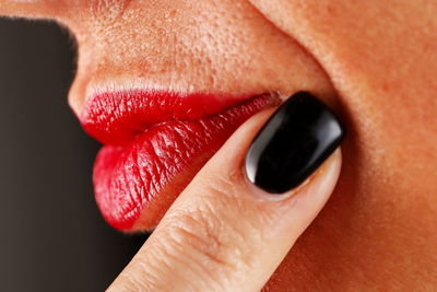 Extreme close-up of woman finger touching lips