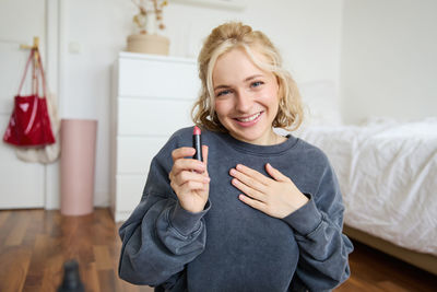 Portrait of smiling young woman using mobile phone