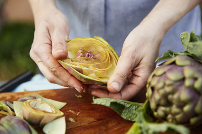 Person cutting fresh artichokes