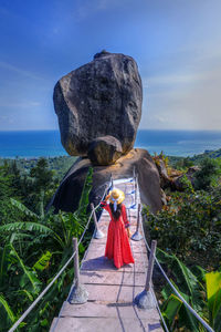 Asian woman tourist in red dress sightseeing  the view of overlap stone at koh samui in thailand