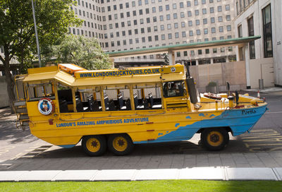 Side view of yellow car on city street