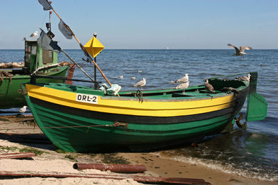 Boats moored on beach against sky