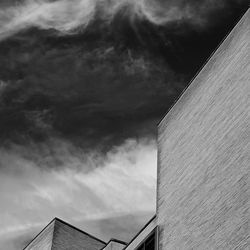 Low angle view of buildings against cloudy sky