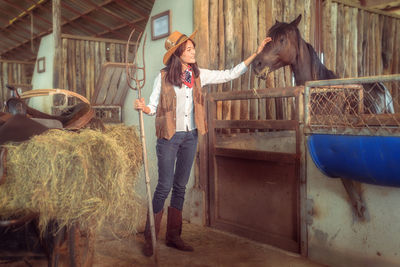 Portrait of young woman standing in stable