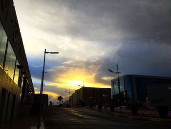 Buildings against cloudy sky at sunset