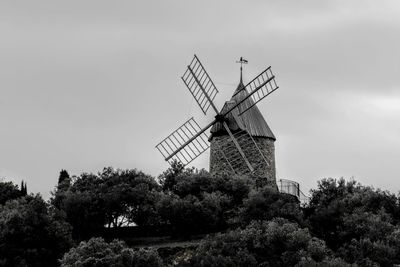 Low angle view of traditional windmill against sky