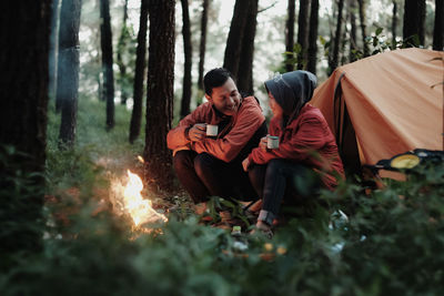 A young couple enjoying their holiday by camping in the forest