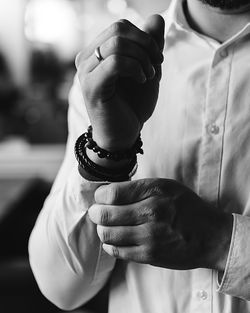 Midsection of young man getting dressed at home