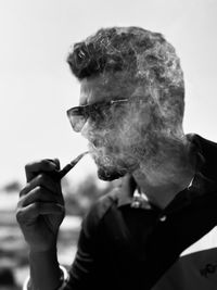 Side view of man smoking cigarette against white background