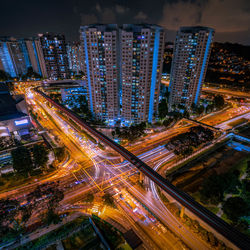 High angle view of illuminated city street and buildings at night