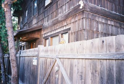 Low angle view of bird perching on wooden building