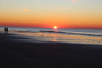 Scenic view of beach against sky during sunset