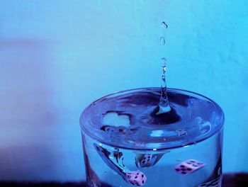 Close-up of dice falling on water in drinking glass