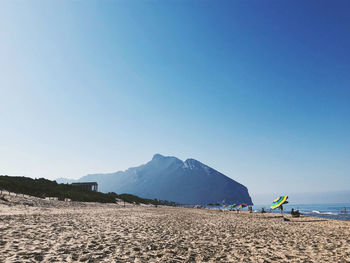 Scenic view of beach against clear blue sky