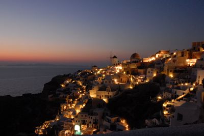 High angle view of illuminated houses against sky at sunset