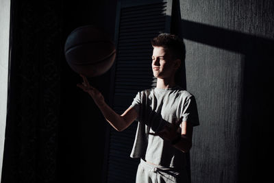 Young man looking at camera while standing against wall