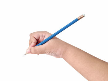 Close-up of woman hand holding pencils against white background