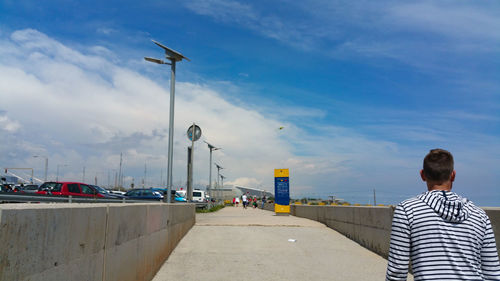 Rear view of man in city against sky