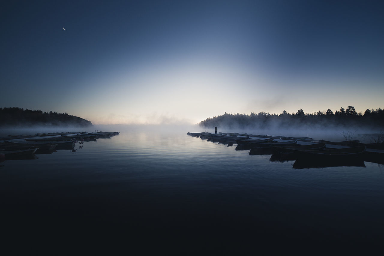 Scenic view of river against blue sky at dusk