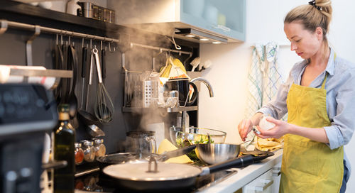 Mid adult woman preparing food at kitchen