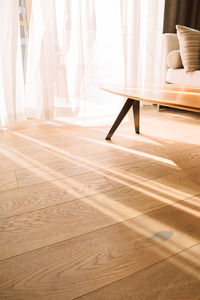 Modern room interior with an open window in minimal style. transparent tulle with morning sun rays 