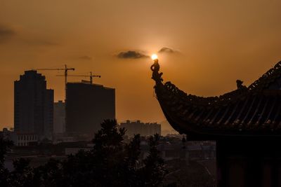 Silhouette roof of tianxin pavilion against sky during sunset