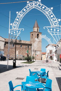 Street amidst buildings in city against blue sky