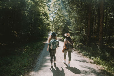 Full length of woman walking on road in forest