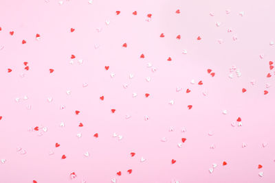 Low angle view of pink balloons against white background