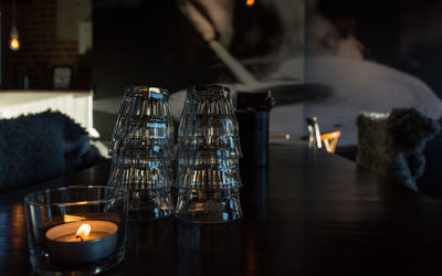 High angle view of lit tea light and glasses on table