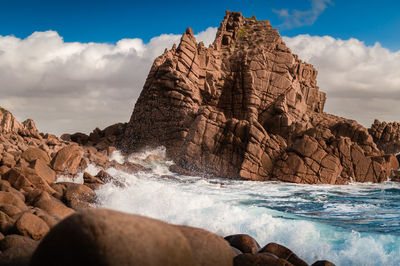 Scenic view of rocks on beach against sky