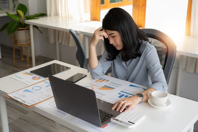 Young woman using laptop at table