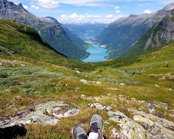 Low section of person on mountain against sky
