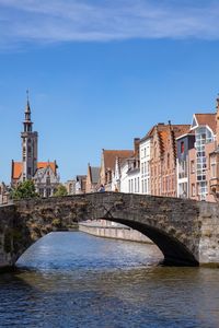 Bridge over river against buildings in city